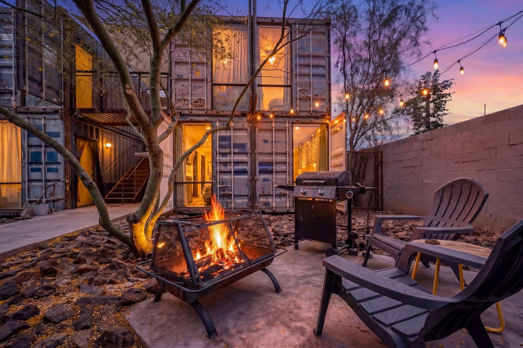Phoenix Airbnb courtyard at twilight, fire pit lit and string lights on