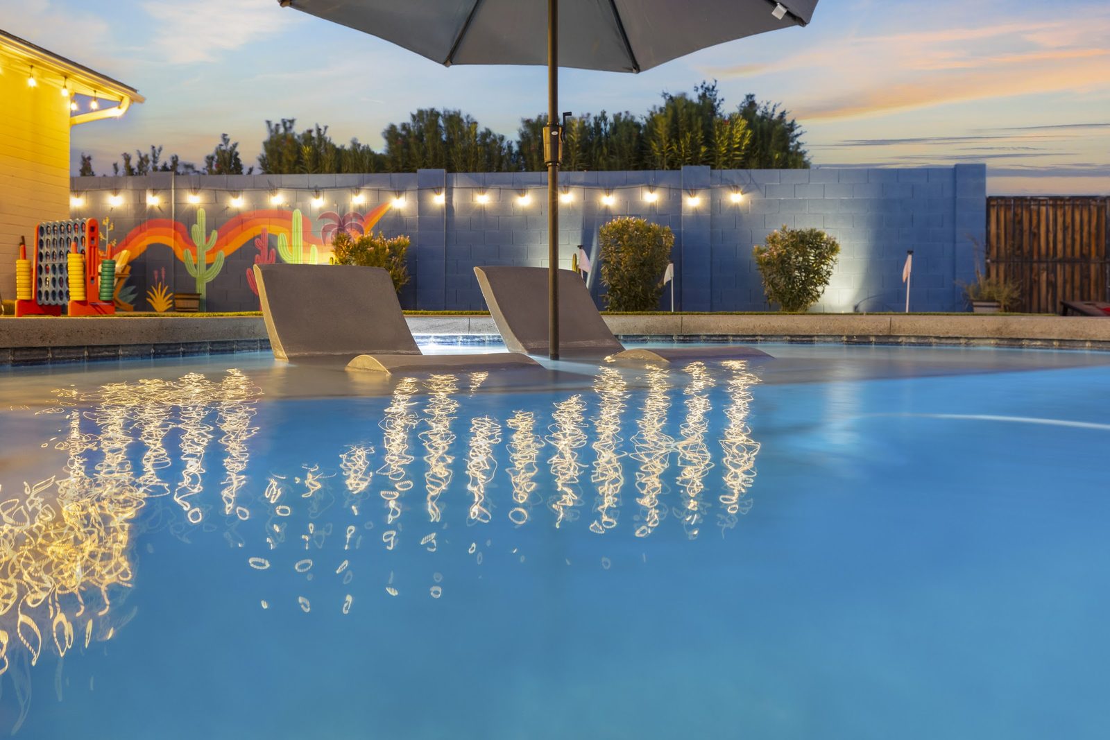 Arizona rental pool lit at twilight with string lights overhead