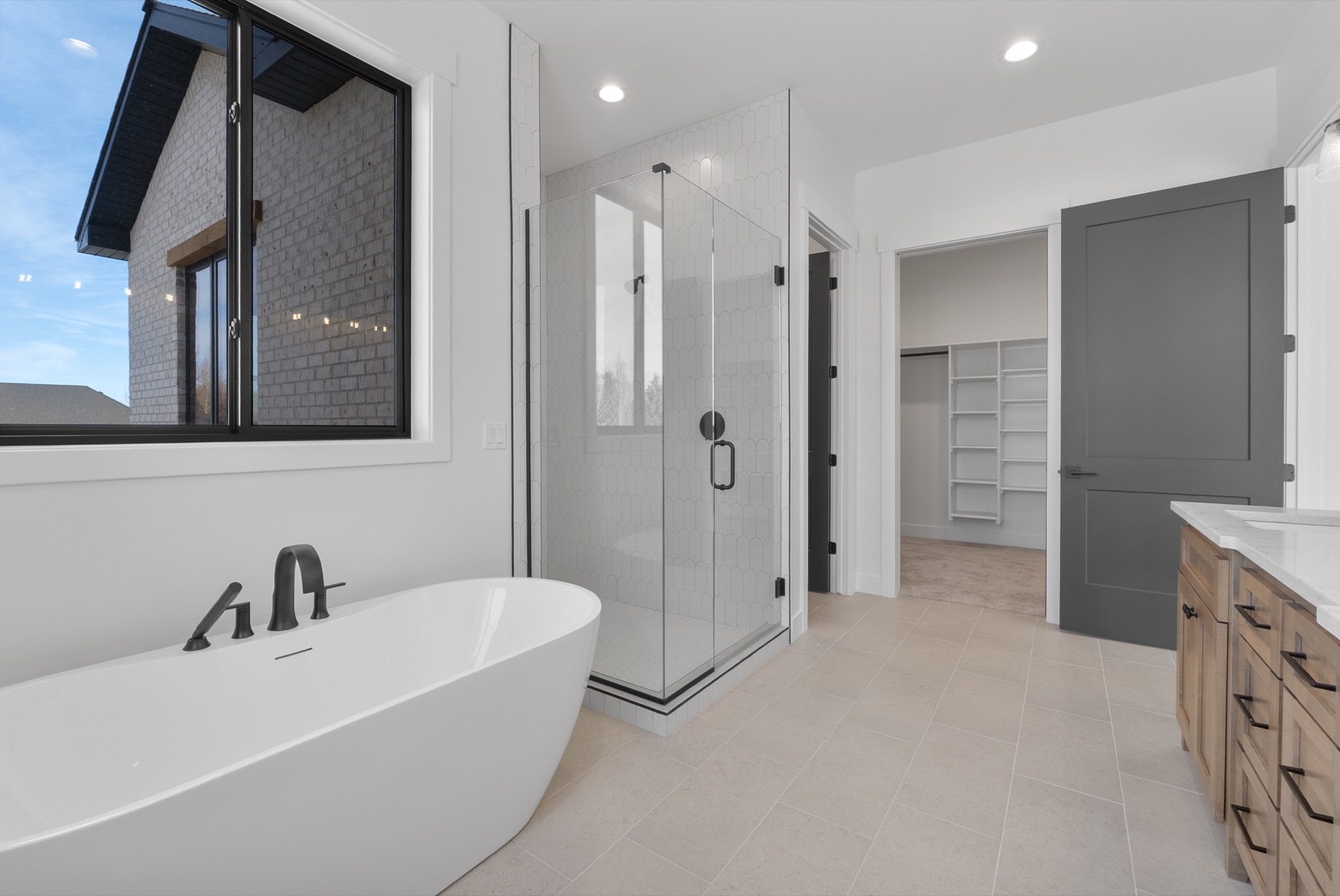 Bathroom with wood vanity, freestanding tub, and glass shower