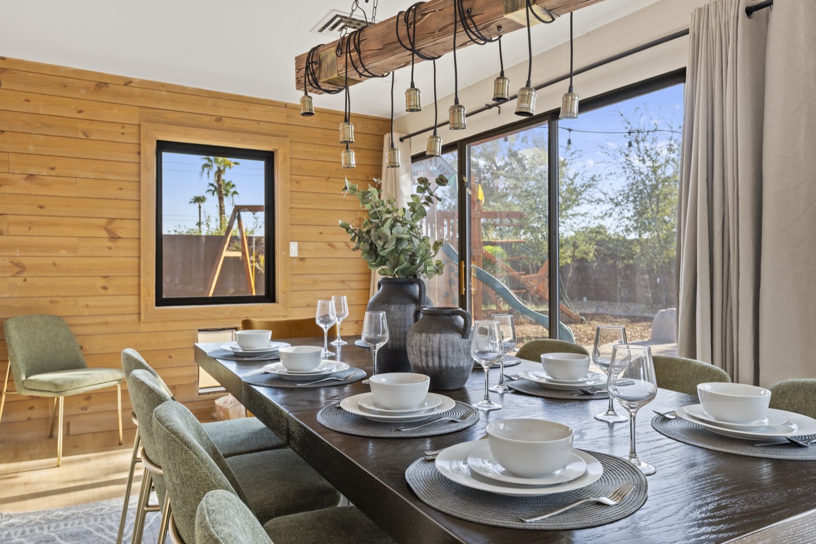 Dining table styled with place settings and greenery in a short-term rental