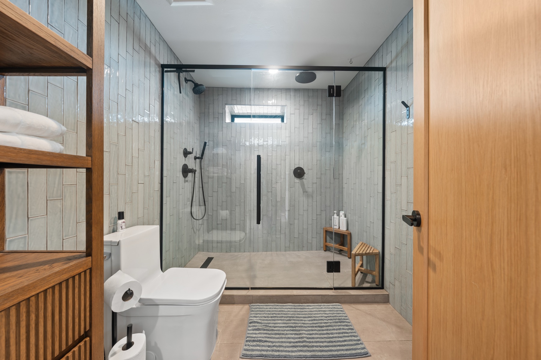 Glass walk-in shower with matte black fixtures in a vacation rental bath