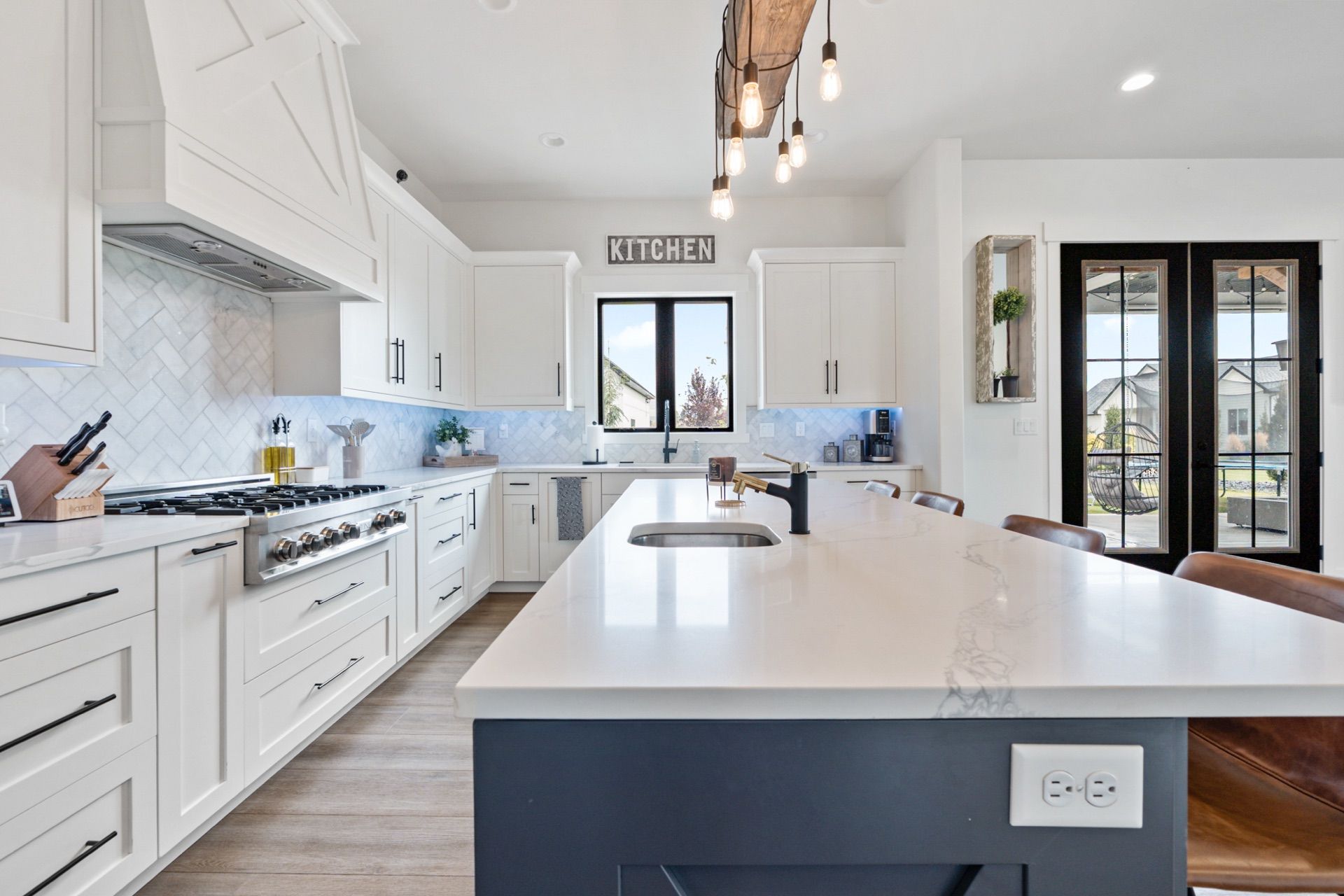 Bright white kitchen with a navy island, styled for a listing