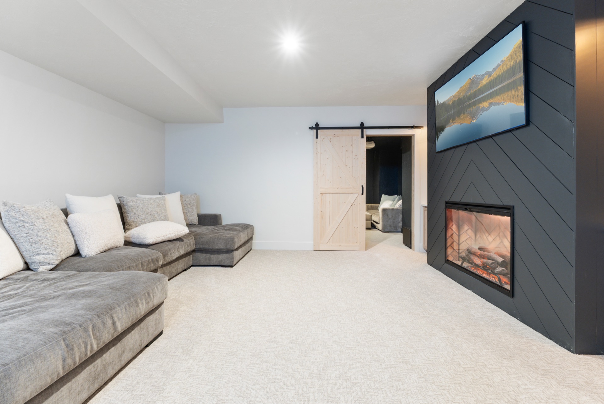 Second media lounge with barn door and grey sectional