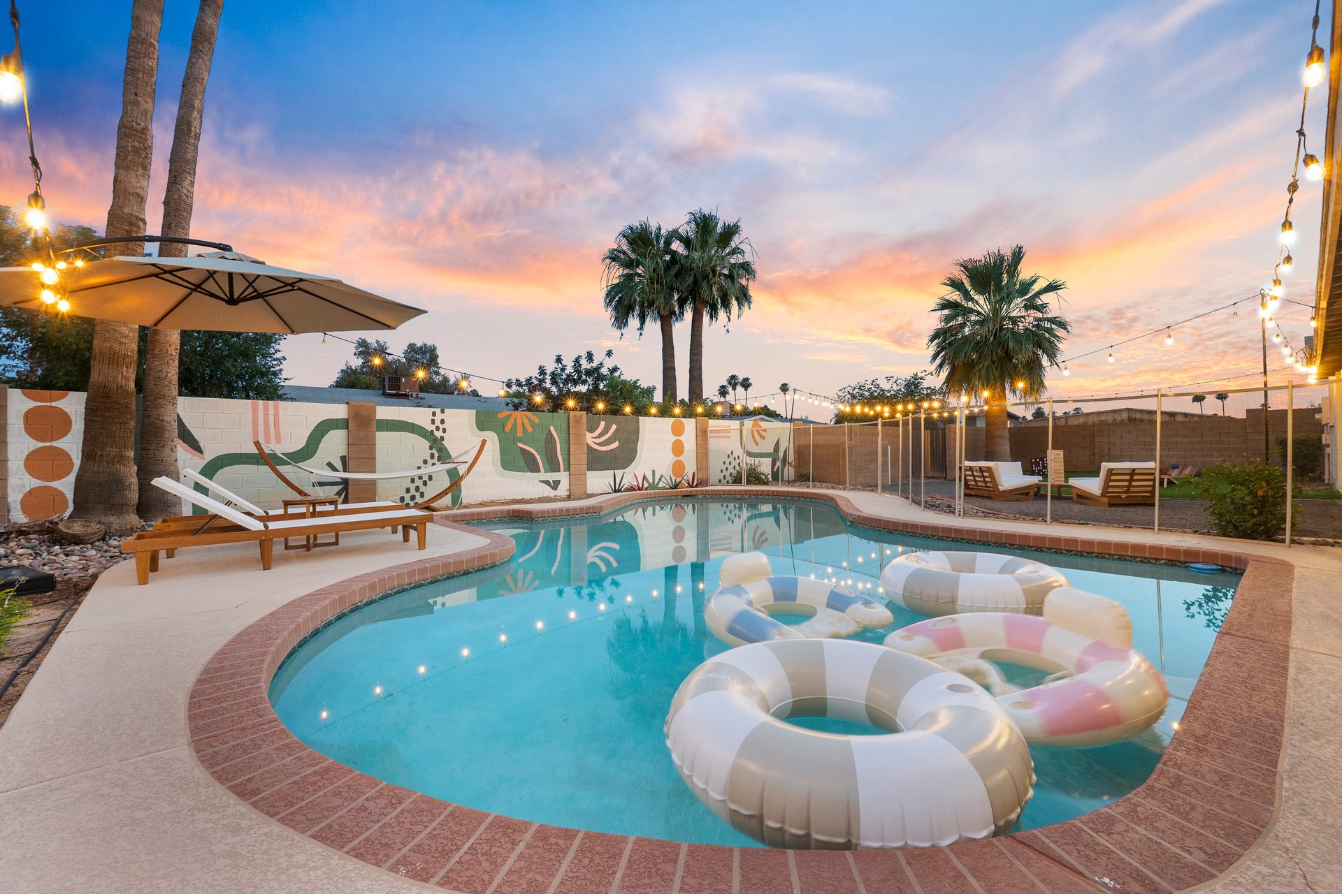 Tempe vacation rental pool at blue hour with floats and string lights